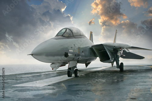 Photo: F-14 jet fighter on an aircraft carrier deck beneath dramatic cl F-14 jet fighter on an aircraft carrier deck beneath dramatic cl