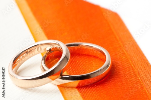 Photo: gold wedding rings near orange ribbon gold wedding rings near orange ribbon