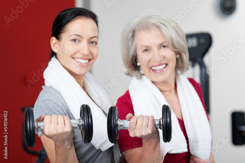 Photo: zwei frauen mit hanteln im fitnessstudio zwei frauen mit hanteln im fitnessstudio