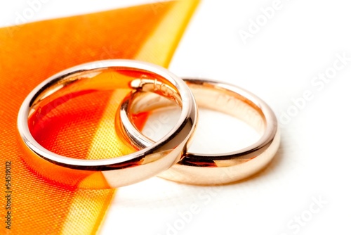 Photo: gold wedding rings near orange ribbon gold wedding rings near orange ribbon