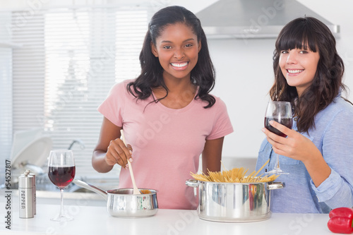 Photo: Happy friends preparing dinner together Happy friends preparing dinner together
