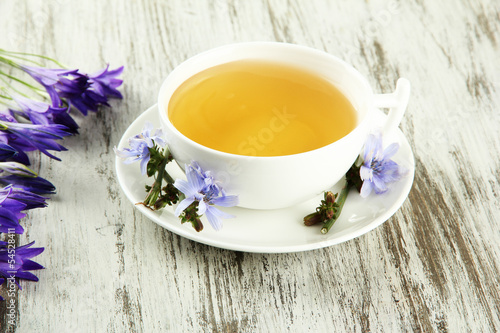 Photo: Cup of tea with chicory, on wooden background Cup of tea with chicory, on wooden background