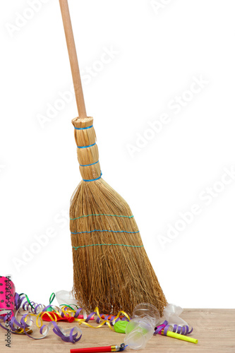 Photo: Broom sweep the trash after a party on white background Broom sweep the trash after a party on white background