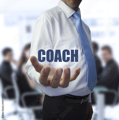 Photo: Elegant businessman holding the word coach Elegant businessman holding the word coach