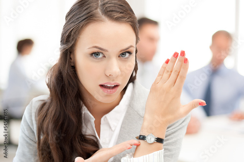 Photo: businesswoman pointing at her watch businesswoman pointing at her watch