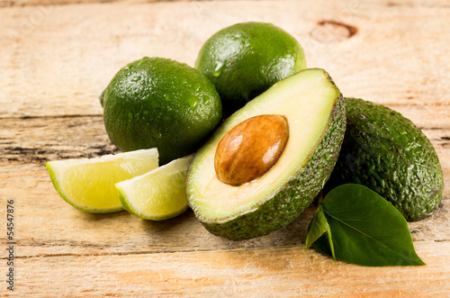 Photo: avocado and limes on wooden background avocado and limes on wooden background