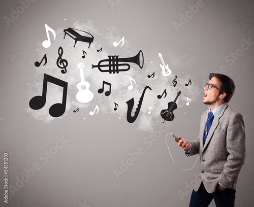 Photo: attractive young man singing and listening to music with musical attractive young man singing and listening to music with musical