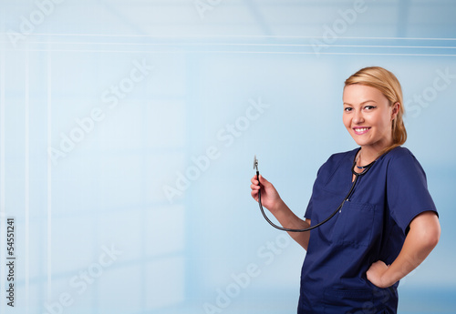 Photo: Pretty nurse in hospital listening to empty copy space with sthe Pretty nurse in hospital listening to empty copy space with sthe