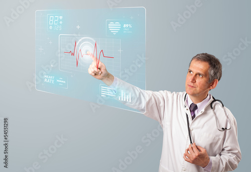 Photo: Middle aged doctor pressing modern medical type of button Middle aged doctor pressing modern medical type of button