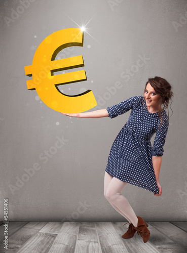 Photo: Beautiful girl holding a big 3d gold euro sign Beautiful girl holding a big 3d gold euro sign