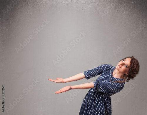 Photo: Pretty woman presenting an empty copy space Pretty woman presenting an empty copy space