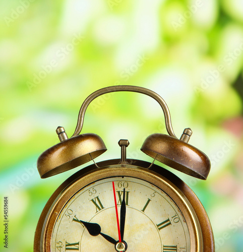 Photo: Old alarm clock on bright background Old alarm clock on bright background