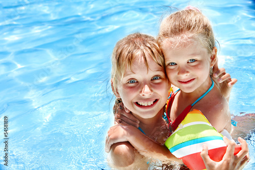 Photo: Kids with armbands in swimming pool. Kids with armbands in swimming pool.