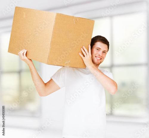 Photo: smiling man carrying carton box smiling man carrying carton box
