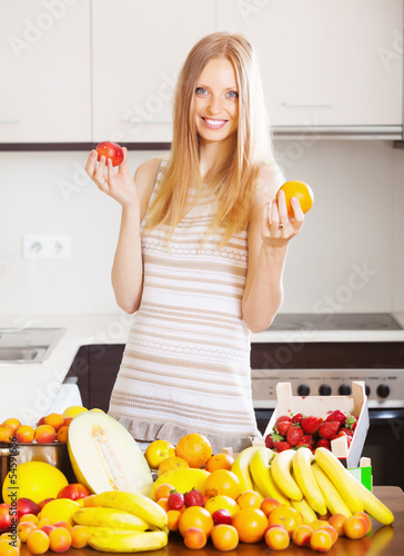 Photo: blonde long-haired woman with heap of ripe fruits blonde long-haired woman with heap of ripe fruits