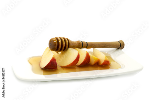 Photo: Honey dripping on red apple slices isolated on white Honey dripping on red apple slices isolated on white