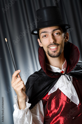 Photo: Magician in the dark room with wand Magician in the dark room with wand