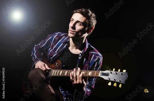 Photo: Man playing guitar during concert Man playing guitar during concert