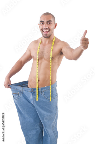 Photo: Man in dieting concept with oversized jeans Man in dieting concept with oversized jeans