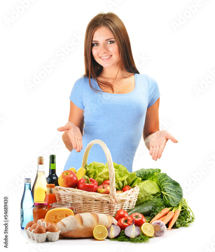 Photo: Young woman with assorted grocery products isolated on white Young woman with assorted grocery products isolated on white