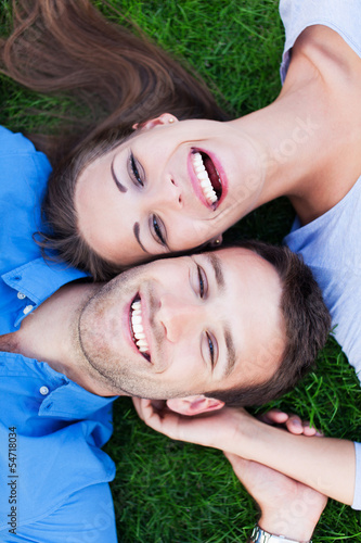 Photo: Young couple lying on grass Young couple lying on grass