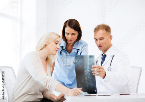 Photo: doctors with patient looking at x-ray doctors with patient looking at x-ray