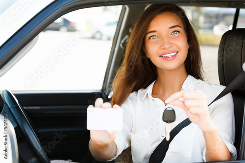 Photo: girl in a car showing a key and an empty white card girl in a car showing a key and an empty white card