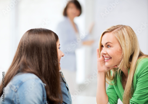 Photo: student girls gossiping at school student girls gossiping at school