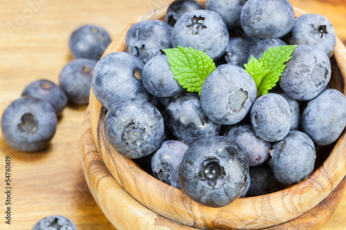 Photo: Blueberries in olive wood bowl , close up Blueberries in olive wood bowl , close up