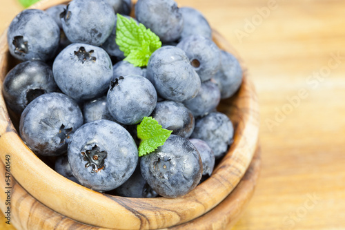 Photo: Blueberry. Blueberries in olive wood bowl , close up . Blueberry. Blueberries in olive wood bowl , close up .