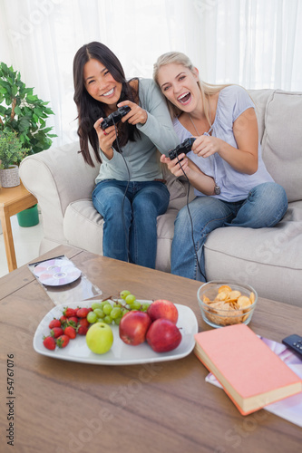 Photo: Happy friends playing video games and laughing Happy friends playing video games and laughing