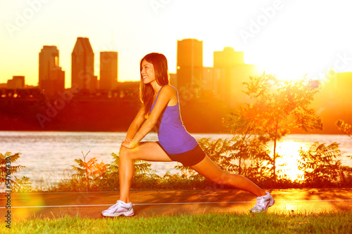 Photo: Woman runner stretching legs after running Woman runner stretching legs after running