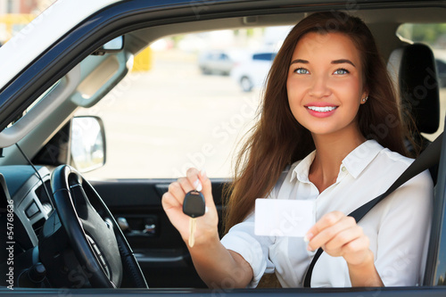 Photo: girl in a car showing a key and an empty white card girl in a car showing a key and an empty white card