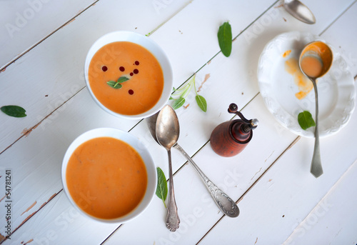 Photo: Bowl of soup with pumpkin on white wooden table healthy diet Bowl of soup with pumpkin on white wooden table healthy diet