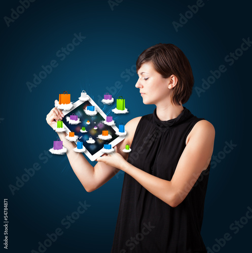 Photo: woman holding modern tablet with colorful shopping bags on cloud woman holding modern tablet with colorful shopping bags on cloud