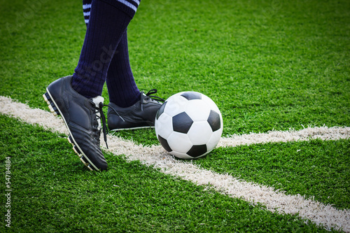Photo: foot kicking soccer ball on corner foot kicking soccer ball on corner