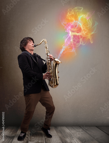 Photo: Attractive musician playing on saxophone with colorful abstract Attractive musician playing on saxophone with colorful abstract
