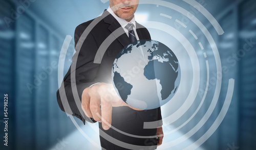 Photo: Businessman touching earth on futuristic interface Businessman touching earth on futuristic interface