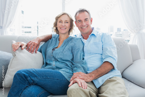 Photo: Middle aged couple relaxing on the couch Middle aged couple relaxing on the couch
