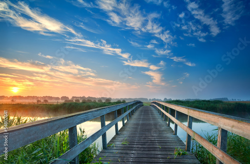 Photo: charming wooden bridge over river charming wooden bridge over river