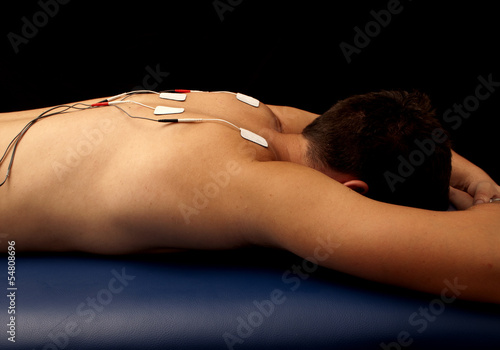 Photo: Man with TENS on his back Man with TENS on his back