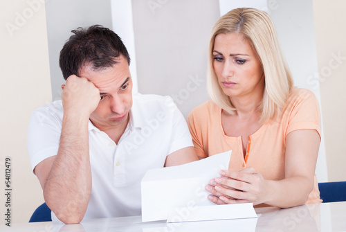 Photo: Shocked couple looking at bill Shocked couple looking at bill