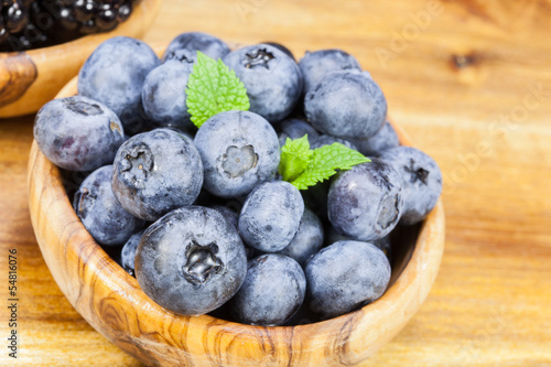 Photo: Blueberry. Blueberries in olive wood bowl, close up Blueberry. Blueberries in olive wood bowl, close up