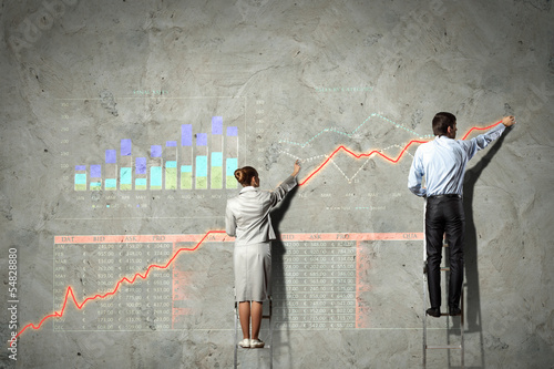Photo: businesspeople drawing diagrams on wall businesspeople drawing diagrams on wall