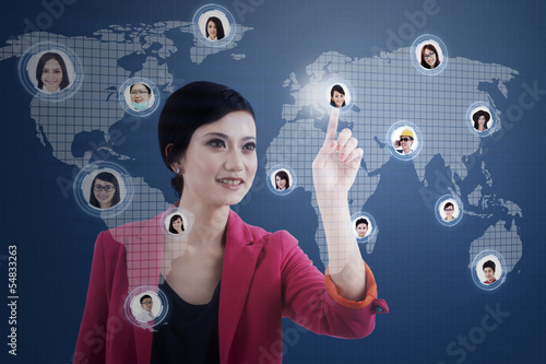 Photo: Businesswoman click on digital head on blue Businesswoman click on digital head on blue