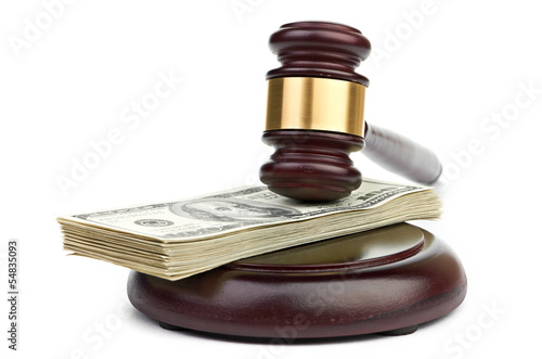 Photo: Law gavel on a stack of American money. Law gavel on a stack of American money.