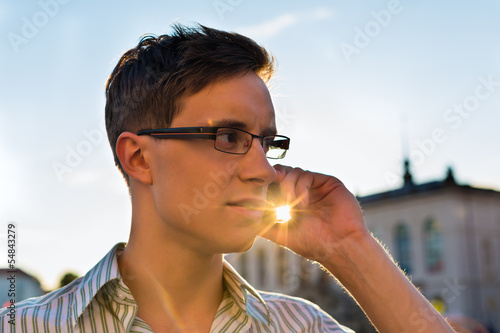 Photo: Man taking a call with mobile phone Man taking a call with mobile phone