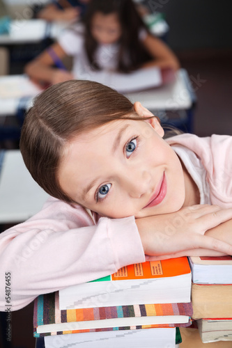 Photo: Happy Schoolgirl Leaning On Stack Of Books Happy Schoolgirl Leaning On Stack Of Books