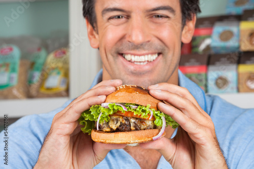 Photo: Happy Man Holding Bugger In Grocery Store Happy Man Holding Bugger In Grocery Store