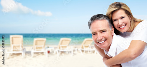 Photo: Happy senior couple on a tropical beach. Happy senior couple on a tropical beach.